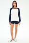 A woman faces forward on a plain white background wearing the SPLITS59 Andie Oversized Colorblock Fleece in Indigo/White, paired with navy modal spandex shorts and white Adidas sneakers.