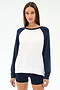 A woman wears the Andie Oversized Colorblock Fleece in Indigo/White by SPLITS59, featuring white with indigo sleeves and matching shorts, made from soft modal spandex, standing against a plain light background.