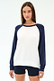 A woman wears the Andie Oversized Colorblock Fleece in Indigo/White by SPLITS59, featuring white with indigo sleeves and matching shorts, made from soft modal spandex, standing against a plain light background.