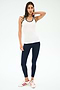A person stands against a plain background wearing the SPLITS59 Ashby Rib Tank in White/Indigo, paired with navy leggings and white sneakers with red stripes—ideal attire for yoga or gym workouts.