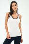 A woman stands against a plain background wearing the SPLITS59 Ashby Rib Tank in White/Indigo with dark pants, looking at the camera—an ideal outfit for yoga or gym sessions.