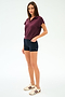 A woman stands against a white background wearing the SPLITS59 Evie Fleece Sleeveless Polo in Dark Cherry, paired with navy fitted shorts and cream sneakers with maroon stripes.
