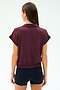 A woman with straight brown hair is seen from the back wearing the SPLITS59 Evie Fleece Sleeveless Polo in Dark Cherry and black shorts against a plain light background.