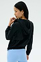 A woman wearing the SPLITS59 Megan Woven Nylon Jacket in black stands facing away, looking over her shoulder against a plain light background.