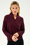 A person with long hair dressed in the cozy SPLITS59 Birdie Fleece Half Zip in Dark Cherry and black pants stands against a plain backdrop.