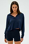 Person wearing the SPLITS59 Joan Fleece Polo Sweatshirt in navy with matching shorts, standing against a plain background.