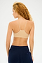 A person with curly hair wears the Loren Seamless Bra in nude by Splits59 and navy blue pants, facing away from the camera against a plain background. The outfit provides comfort during gym workouts.