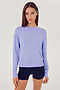 Front view of woman with dark brown hair wearing a light purple crewneck sweatshirt and black shorts