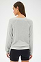 A woman in a SPLITS59 Bennie Fleece V-Neck Sweatshirt in Heather Grey/White and black shorts stands facing away, with her head slightly turned to the left.