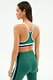 A woman is shown from the back against a white background wearing the SPLITS59 Bianca Rigor Bra in Arugula/White, paired with matching high-waisted leggings made from a soft nylon-spandex blend.