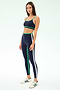 A woman wears the SPLITS59 Sam High Waist Rigor 7/8 leggings in Indigo/Spearmint with a matching sports bra and white sneakers, standing against a plain light background.