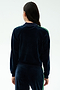 A person with long dark hair, seen from behind, wears the SPLITS59 Heritage Velour Bomber in Indigo/Grass—ideal for yoga—against a plain light background.