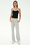 A woman faces forward in a black tank top with white trim, SPLITS59 Raven Fleece Full Length Sweatpant in Heather Grey, and white sneakers, standing against a plain background.