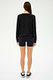 A woman stands with her back to the camera wearing a SPLITS59 Bennie Fleece V-Neck Sweatshirt in sleek black, paired perfectly with matching shorts and sneakers.
