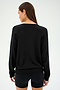 Individual wearing a stylish SPLITS59 Bennie Fleece V-Neck Sweatshirt in black and shorts, facing away.