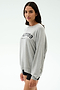 A woman models the SPLITS59 Andie Oversized Fleece Varsity Graphic Sweatshirt in heather grey with "Splits59 Los Angeles" text, paired with black shorts, standing against a plain light background and facing slightly to the side.