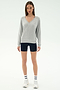 A woman faces forward against a white background wearing the SPLITS59 Bennie Fleece V Neck Sweatshirt in Heather Grey/White, paired with black shorts, white socks with black stripes, and white sneakers.