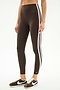 A person wears SPLITS59's Bianca High Waist Rigor 7/8 leggings in Dark Chocolate/White with two white stripes, paired with brown and white sneakers, standing against a plain white background.
