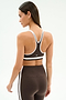 A woman models the SPLITS59 Bianca Rigor Bra in Dark Chocolate/White, paired with matching high-waisted leggings, seen from the back against a light backdrop—perfect for high-impact workouts or intense gym sessions.