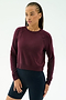 A person with braided hair wears the SPLITS59 Brooks Fleece Long Sleeve Sweatshirt in Dark Cherry and black shorts, standing against a plain white background.