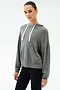 A person wears the SPLITS59 Joey Long Sleeve Hoodie in Medium Heather Grey and black spandex leggings, standing against a plain light background.