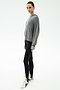 A person stands against a plain background wearing the SPLITS59 Joey Long Sleeve Hoodie in Medium Heather Grey, black spandex leggings, and white sneakers with black details.