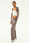 A person wearing a white tube top and a gray cardigan, paired with the SPLITS59 Raven Fleece Full Length Sweatpant in Lentil featuring white drawstrings, stands on a white background.