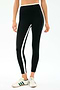 A person wears SPLITS59 Sam High Waist Rigor 7/8 leggings in Black/Military with white and green side stripes, paired with white athletic sneakers featuring green stripes.