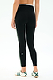 A person is shown from the back wearing SPLITS59 Sam High Waist Rigor 7/8 leggings in Black/Military with a green side stripe and white sneakers, featuring Rigor fabric for a run-tight fit, against a plain background.