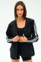 A woman stands against a white background wearing the SPLITS59 Reggie Water Repellent Jacket in black/white.
