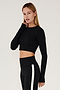 Side view of girl wearing black long sleeve crop top and black leggings with white stripe