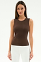 A woman faces the camera in a SPLITS59 Carter Airweight Lite Tank in Dark Chocolate, paired with white pants—ideal Pilates attire—against a plain white background.