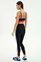 A woman faces away, wearing SPLITS59 Monah High Waist Rigor Legging 7/8 in Black/Cobalt, a black sports bra with red and blue bands, and blue athletic shoes.