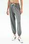A person wearing SPLITS59 Andie Oversized Fleece Sweatpant in Medium Heather Grey and white sneakers, shown from midriff to feet against a plain background—made in Los Angeles and perfect for cool weather workouts.
