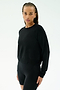 A person with braided hair wears the SPLITS59 Brooks Fleece Long Sleeve Sweatshirt in black, paired with fitted shorts, standing against a plain light background. This classic crewneck is made in Los Angeles for effortless style.