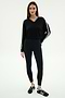 A woman wears the SPLITS59 Ellie Fleece V Neck Sweatshirt in Black/White, featuring white stripes, paired with black leggings and black sneakers with white accents, standing against a plain background.