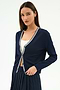A woman stands against a white background wearing the SPLITS59 Bekah Knit Cardigan in indigo/white, crafted from soft rayon, over a white top and navy pleated skirt.