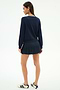 A woman stands facing away against a plain white background, wearing the SPLITS59 Bekah Knit Cardigan in Indigo/White.