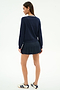 A woman stands facing away against a plain white background, wearing the SPLITS59 Bekah Knit Cardigan in Indigo/White.