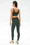 A woman faces away, wearing SPLITS59's Airweight Rib High Waist 7/8 leggings in Military with a matching sports bra and white sneakers, set against a plain white background.