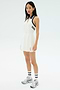 A woman wears the SPLITS59 Austin Rigor Dress in White/Indigo, paired with white socks and silver athletic shoes, standing against a plain light background.