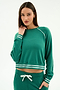 A woman wears the SPLITS59 Brooks Fleece Sweatshirt With Stripe in Arugula/White, paired with matching green drawstring pants, crafted from a soft modal fabric spandex blend, posing against a plain background.