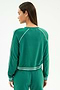 A woman with long straight hair and gold stud earrings wears the SPLITS59 Brooks Fleece Sweatshirt With Stripe in Arugula/White, featuring soft modal fabric and white stripes on the sleeves, cuffs, and waist.