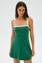 A person in the Monah Rigor Dress - Arugula/White by SPLITS59 stands against a white background, looking at the camera.