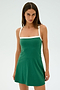 A person in the Monah Rigor Dress - Arugula/White by SPLITS59 stands against a white background, looking at the camera.