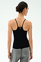 A person shown from the back wears the SPLITS59 Loren Seamless Waist Length Tank in black with gray pants, standing against a plain light background.