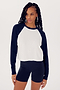 A woman in a Indigo/White Warm Up Crop Fleece Sweatshirt by SPLITS59, paired with black spandex shorts, standing against a white background.