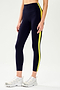 Side view of girl wearing dark blue leggings with a yellow down the side with white shoes
