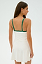 A woman with long hair is wearing the SPLITS59 Monah Rigor Dress in White/Arugula, featuring soft green straps, and is facing sideways against a plain background.