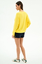 A person faces away wearing the SPLITS59 Andie Oversized Fleece Sweatshirt in bright yellow, paired with navy shorts and white sneakers featuring green stripes, set against a plain white background.